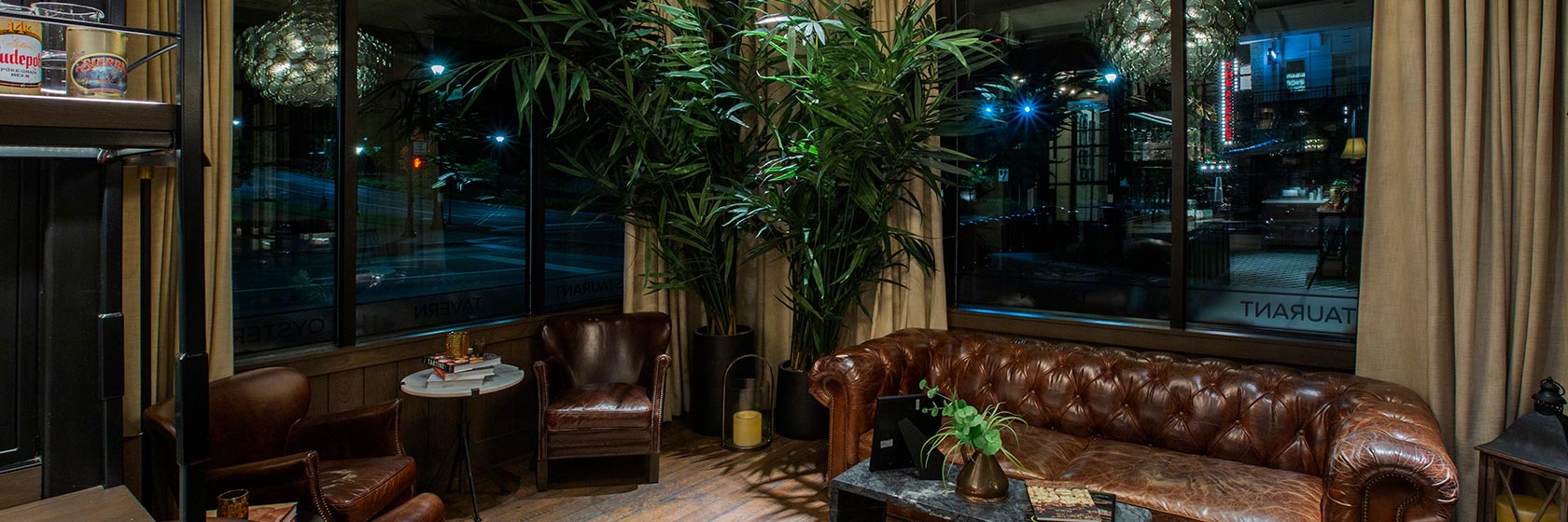 Reception area with leather couch seating at entryway to The Pearl restaurant